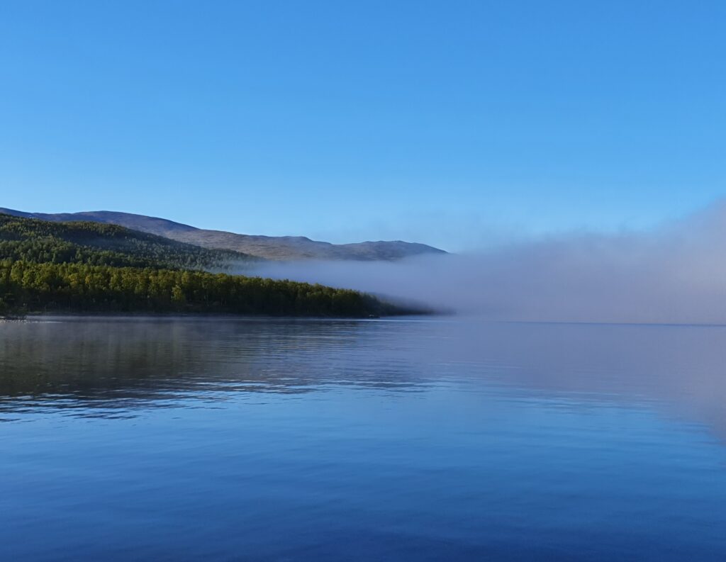 Sommarfj&auml;ll och en sj&ouml; med dimsl&ouml;jor