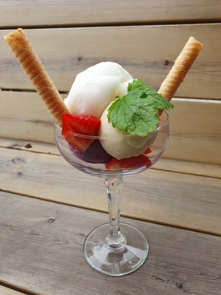 Glasb&auml;gare med tre glasskulor, jordgubbar och r&aring;n